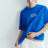Camiseta azul con gráfico y eslogan