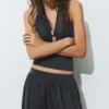 Camiseta sin mangas con cuello halter y detalles metalizados Camiseta sin mangas con cuello halter y detalles metalizados